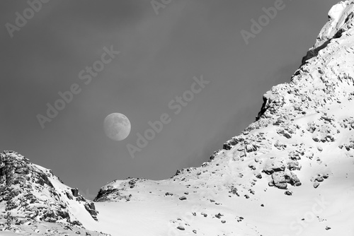 Moonrise over snow-covered mountain in Lofoten