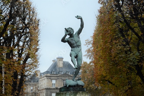 Statue next to trees and palace