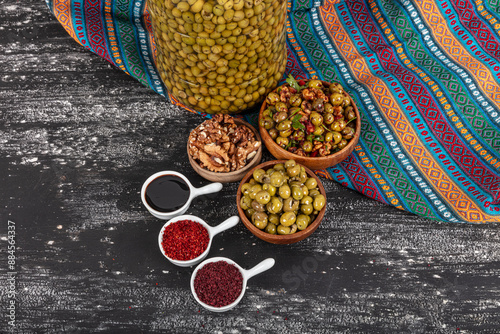 Homemade crushing olive making. Fresh green olives are breaking one by one. Crushing olives with stone. Preparing pickled olives in Turkish style. (Turkish name; kirma zeytin). Pickled Green Olives. photo