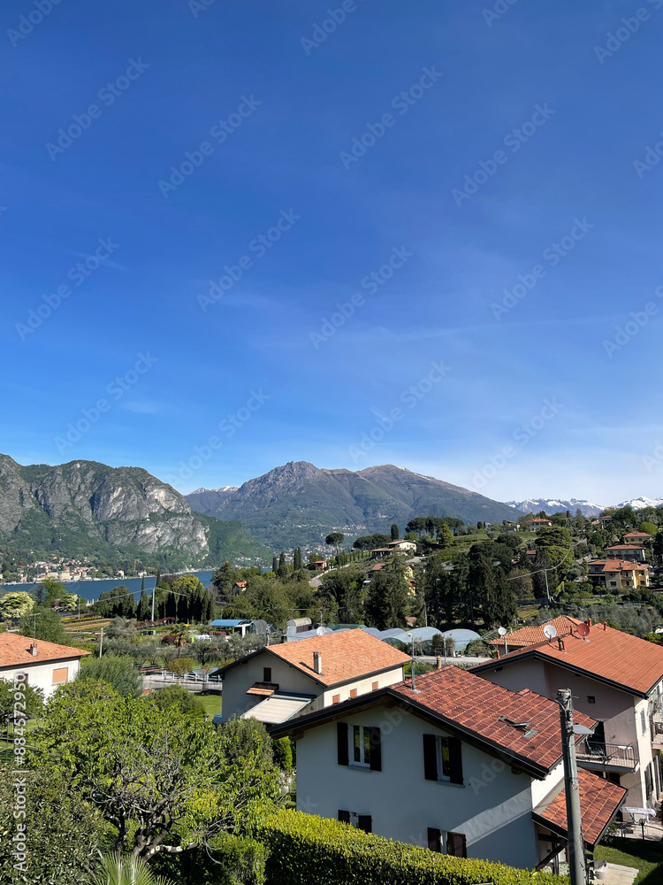Italy, lake Como in the evening. View of the lake and old houses standing above the lake. Mountains around the lake. Red roofs. Green Planet. Spring sunny day. Street in small village on Italy. Italy, lake Como in the evening. View of the lake and old houses standing above the lake. Mountains around the lake. Red roofs. Green Planet. Spring sunny day. Street in small village on Italy.