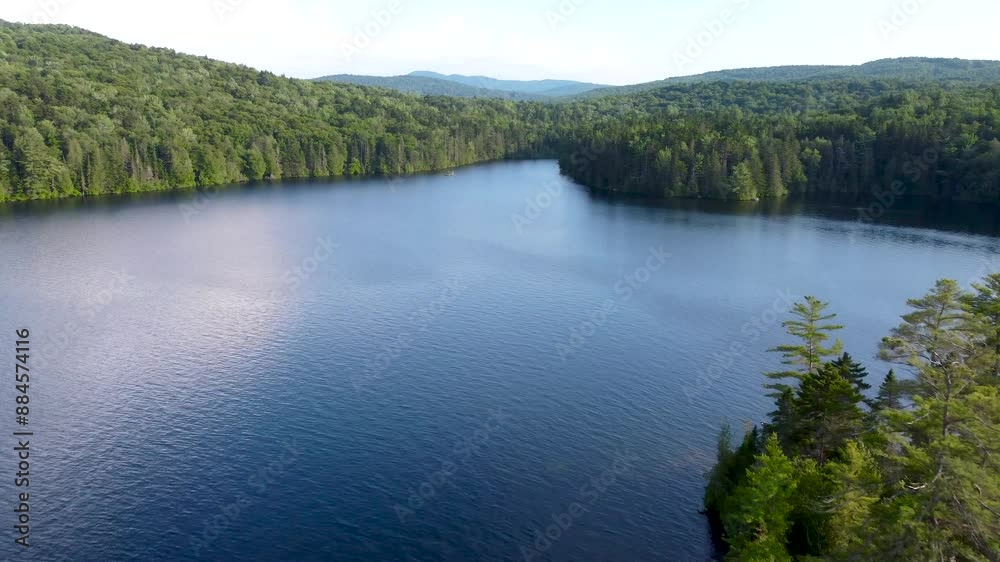 An aerial cinematic view of a New England Lake surrounded by mountains during summer. Maidstone Lake Vermont. An aerial cinematic view of a New England Lake surrounded by mountains during summer. Maidstone Lake Vermont.
