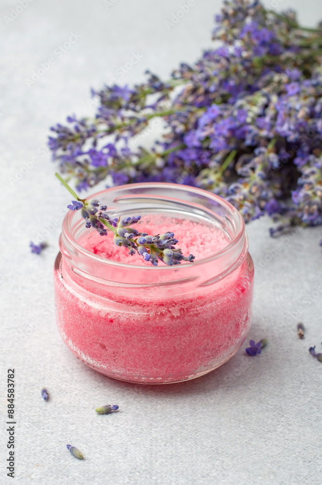 A jar of pink salt body scrub with lavender oil. A jar of pink salt body scrub with lavender oil.