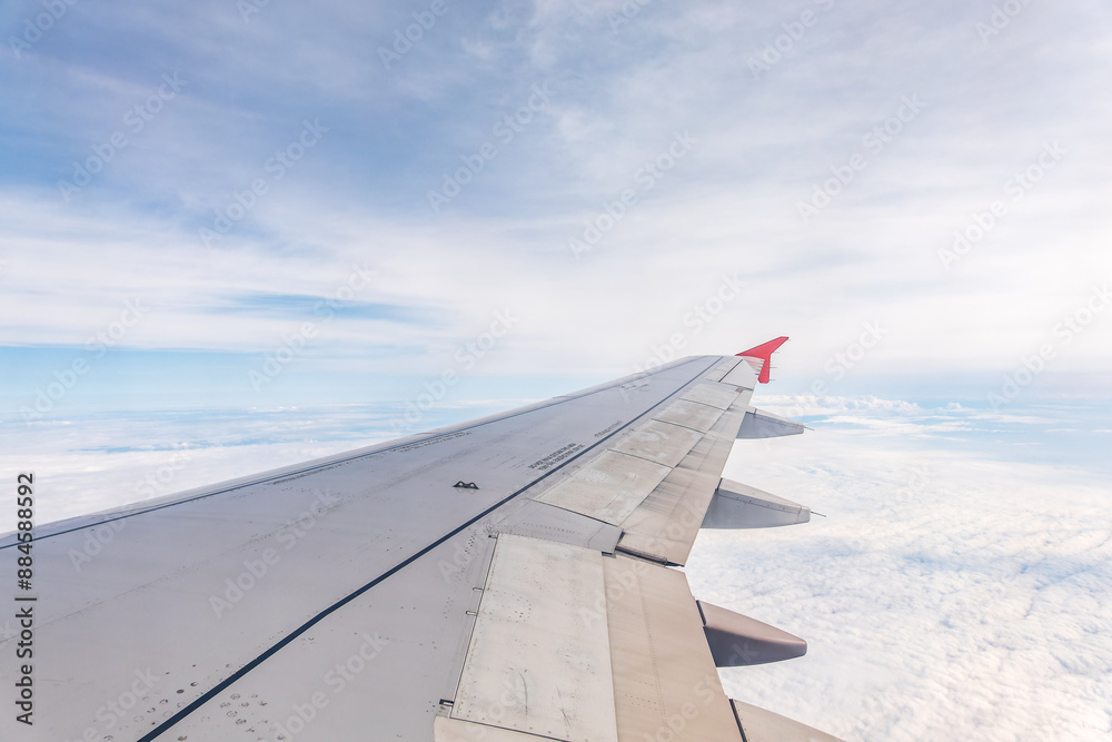 View from the airplane window at a beautiful cloudy sky and the airplane wing View from the airplane window at a beautiful cloudy sky and the airplane wing