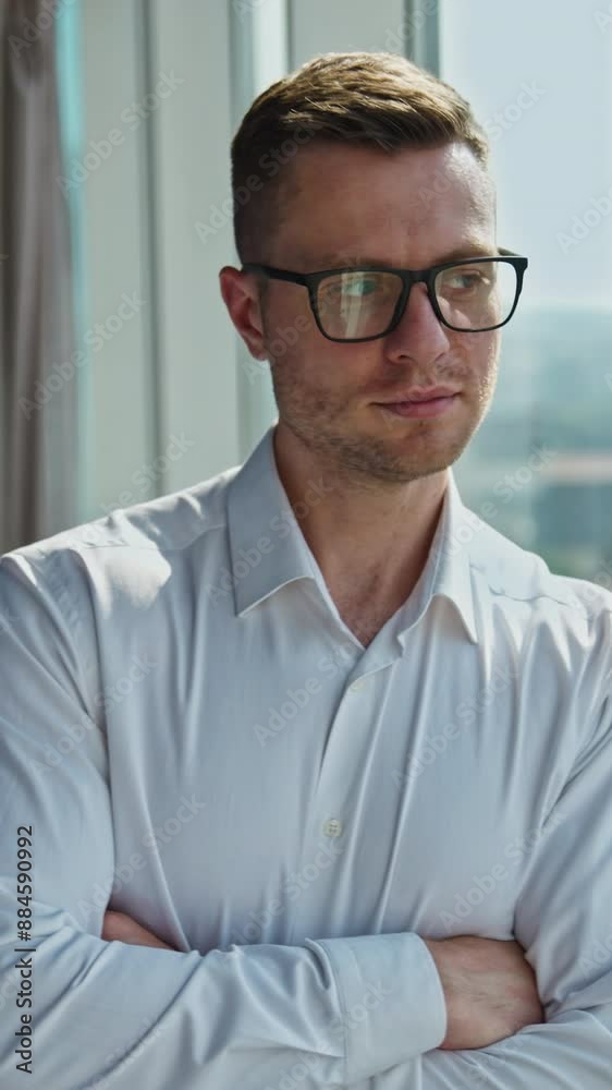 Self-confident mid-aged man in glasses stands near the big window. Man thoughtfully looks into the window, then takes off the glasses. Cityscape in window in blur. Vertical video Self-confident mid-aged man in glasses stands near the big window. Man thoughtfully looks into the window, then takes off the glasses. Cityscape in window in blur. Vertical video