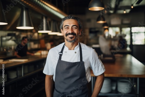 Portrait of a smiling hispanic male chef in kitchen