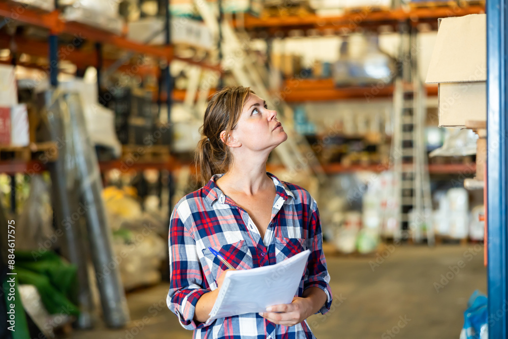 Fototapeta premium Portrait of caucasian woman working in warehouse, checking documentation.