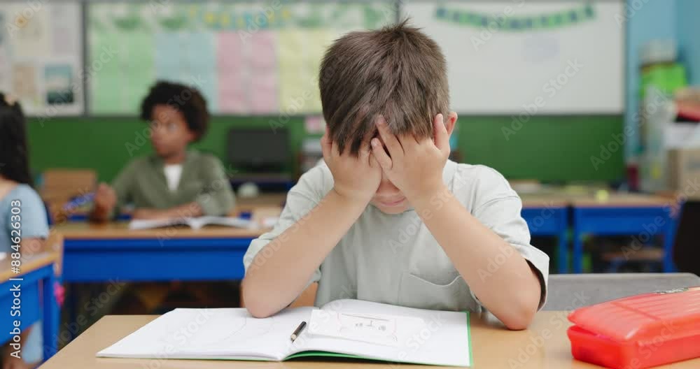 Education, exam and stress with boy student at desk in classroom for development. learning or study. Book, headache and scholarship with child reading at school for academy evaluation or knowledge