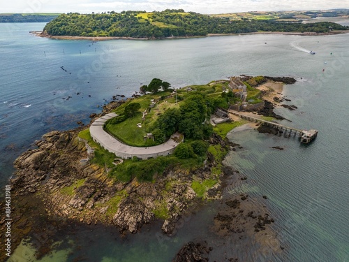 Fotografie Drake's Island in Plymouth Sound, featuring lush greenery, historic buildings, and rocky shores