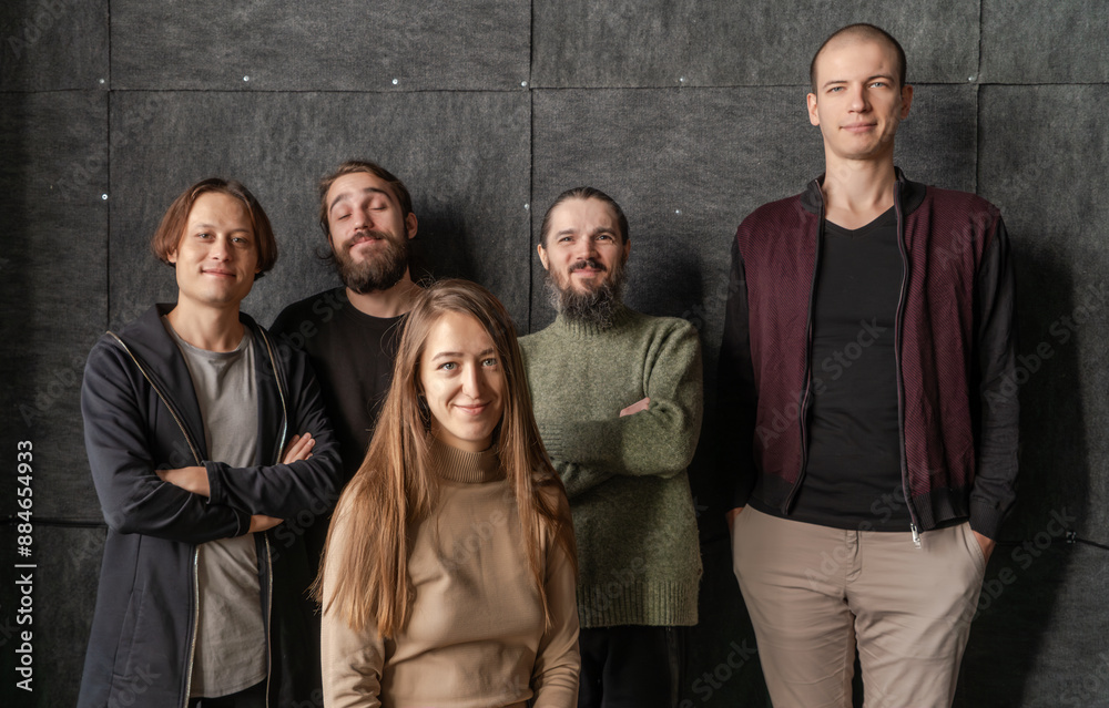 Group portrait of five friends posing together, smiling in front of dark background, camaraderie and togetherness. Group portrait of five friends posing together, smiling in front of dark background, camaraderie and togetherness.