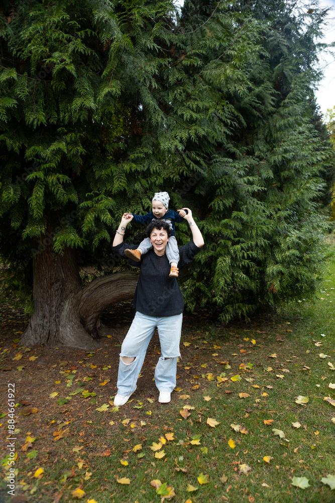 Young mother and her little son having fun in the autumn park. Young mother and her little son having fun in the autumn park.