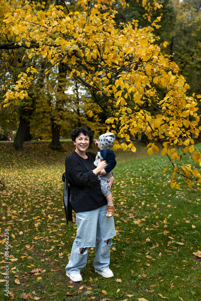 Young mother and her little son having fun in the autumn park. Young mother and her little son having fun in the autumn park.