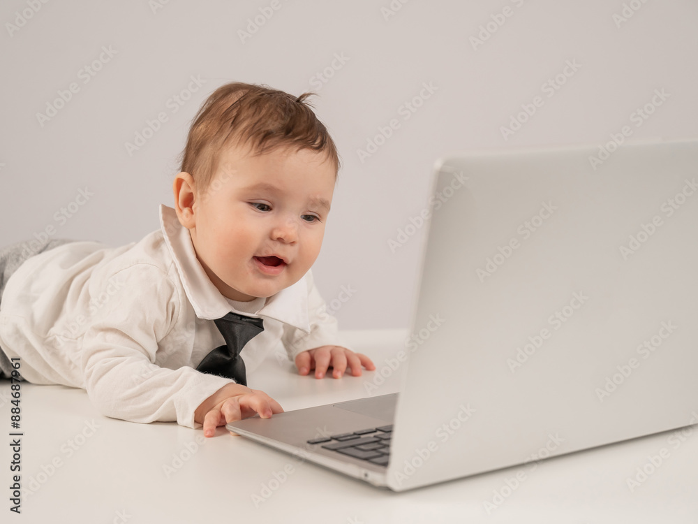 Cute baby boy in a tie working at a laptop. Cute baby boy in a tie working at a laptop.