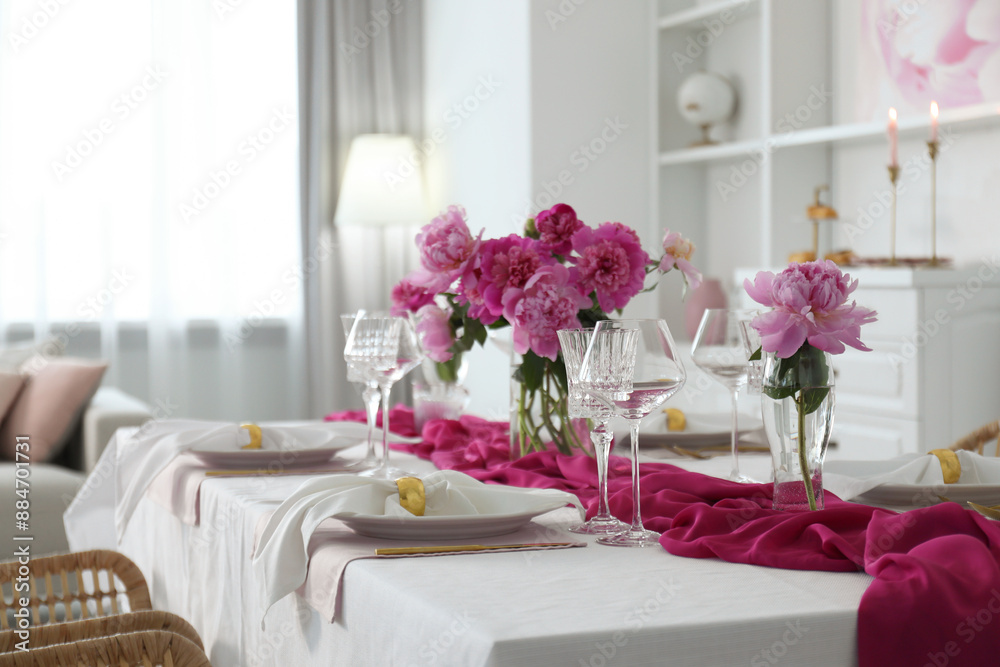 Beautiful table setting with pink peonies in dining room Beautiful table setting with pink peonies in dining room