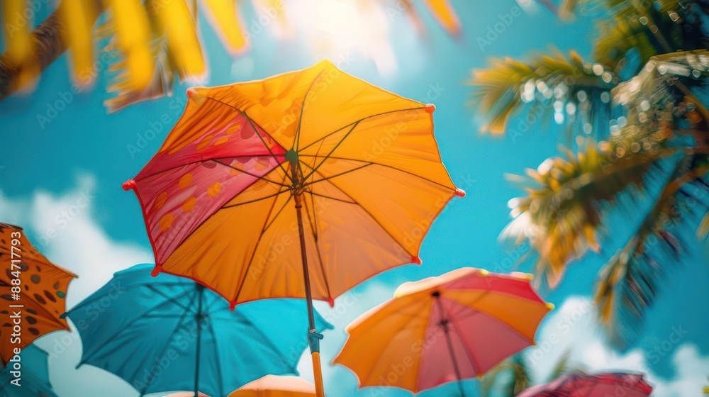 Obraz premium brightly colored umbrellas are in the air near palm trees