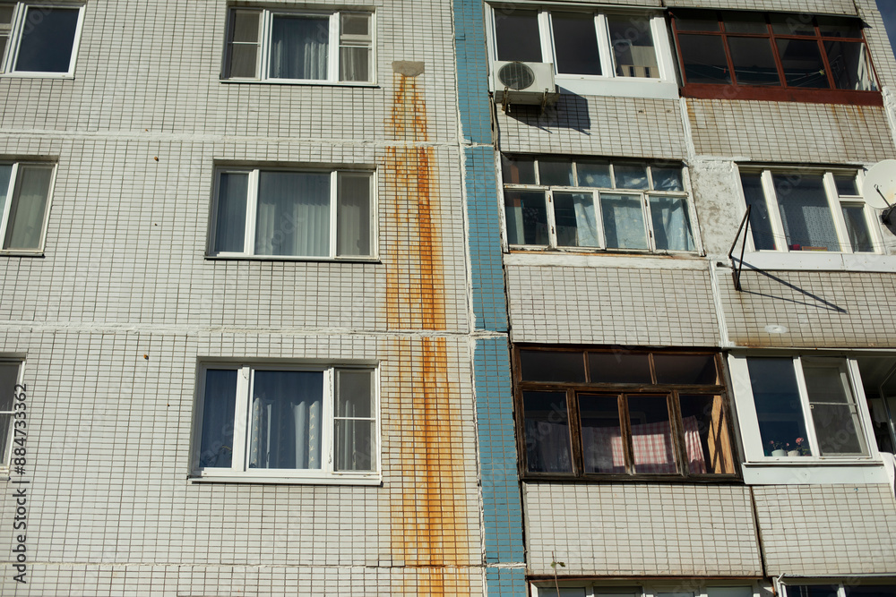 Obraz premium Rusty water on wall. Rust trail. Result of pipe break. Red mud.