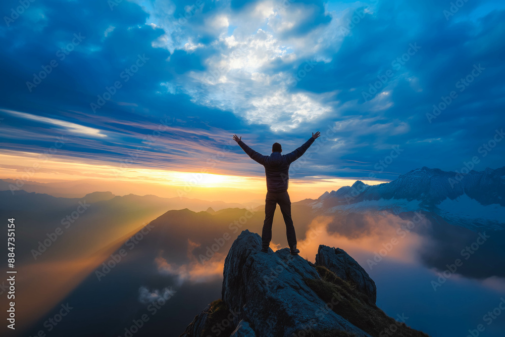 Positive man celebrating on mountain top, with arms raised up Positive man celebrating on mountain top, with arms raised up