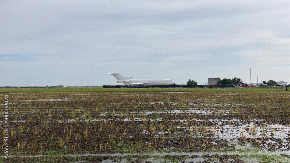 Fototapeta premium Selangor, Malaysia July 22 2023 - Landscape view of the plane in the middle of the paddy field