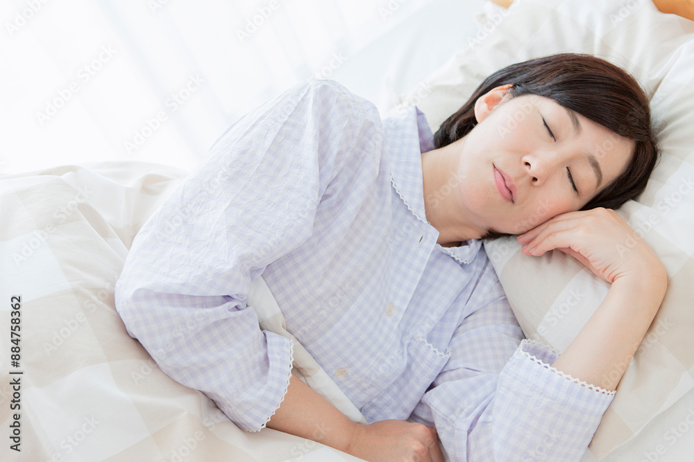ベッドで眠る中年女性