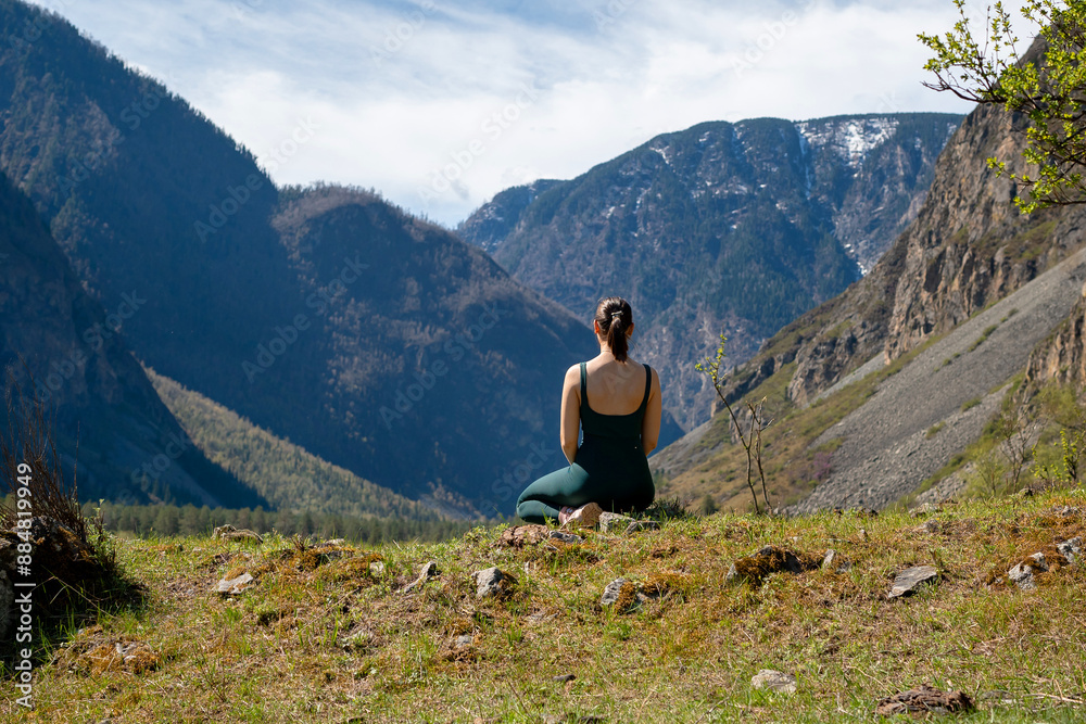 Fototapeta premium Woman meditating, zen yoga meditation practice in nature. Yogi girl is sitting in lotus pose, healthy lifestyle, meditation concept