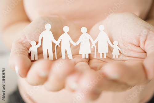 Photos Hands holding multi generational family paper, family wellness, health insurance
