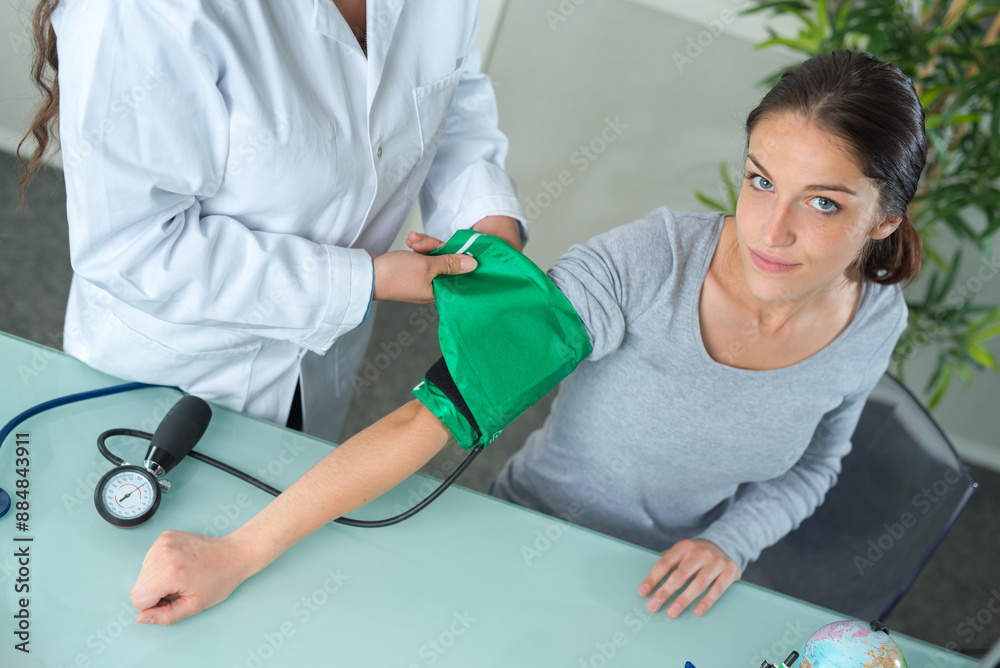 doctor measures the blood pressure of a young patient doctor measures the blood pressure of a young patient