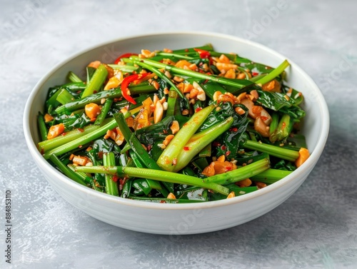 Delicious stir-fried Chinese water spinach with garlic and chili in a white bowl, perfect for a flavorful and healthy meal. photo