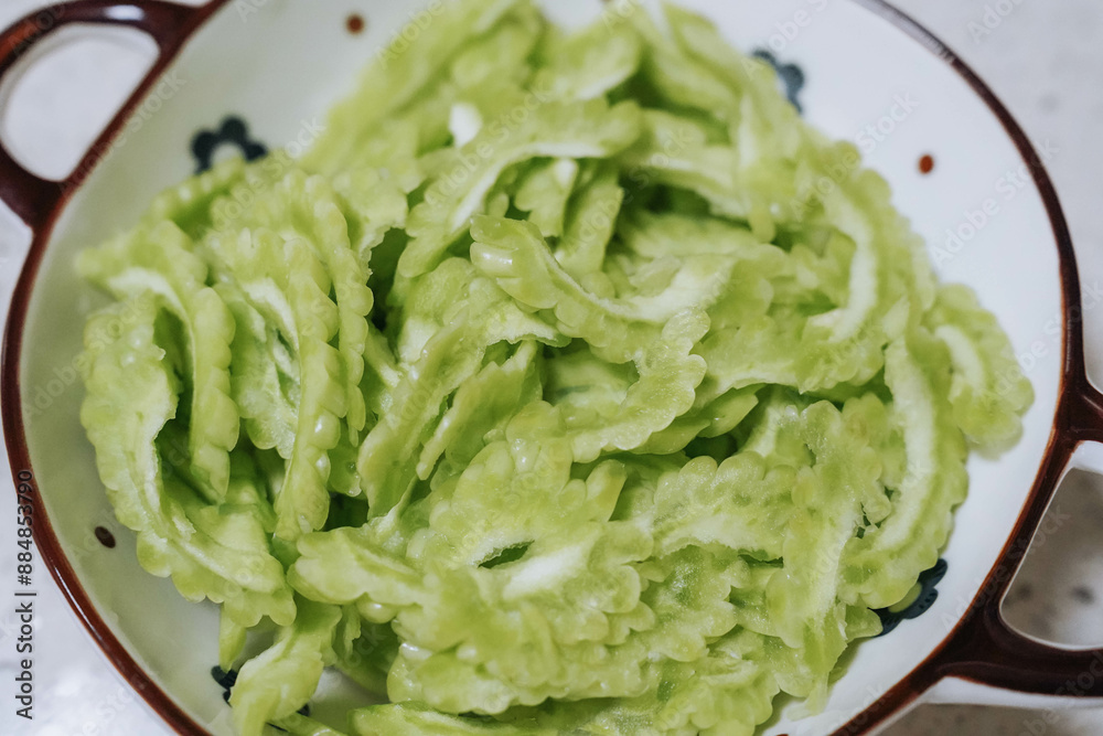 Sliced bitter melon or bitter gourd in plate for cooking Sliced bitter melon or bitter gourd in plate for cooking
