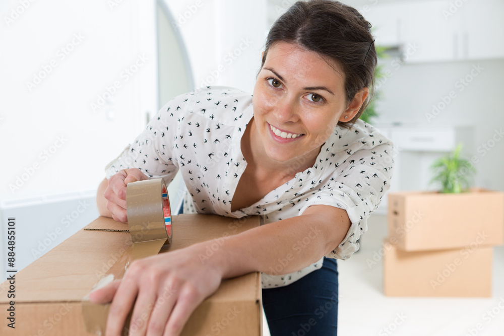 woman closing boxes to move to her new house woman closing boxes to move to her new house