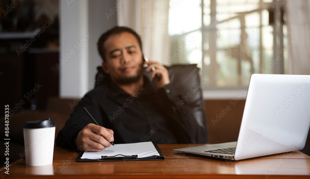 Handsome young Asia man in formal wear talking on smartphone, enjoying conversation at workplace. Young businessman using laptop in his office.
Handsome young Asia man in formal wear talking on smartphone, enjoying conversation at workplace. Young businessman using laptop in his office.