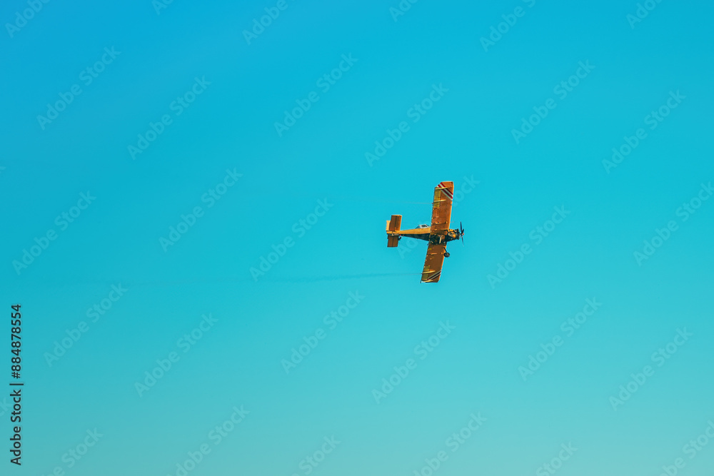 Agricultural aircraft spraying insecticide liquid from the air