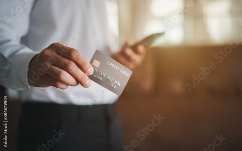 Side view closeup of young man paying with credit card in tech store, copy space
