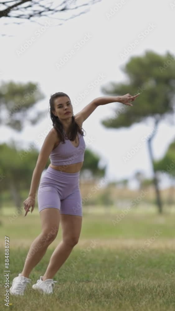 A woman is doing sportive dances for social network in the park A woman is doing sportive dances for social network in the park