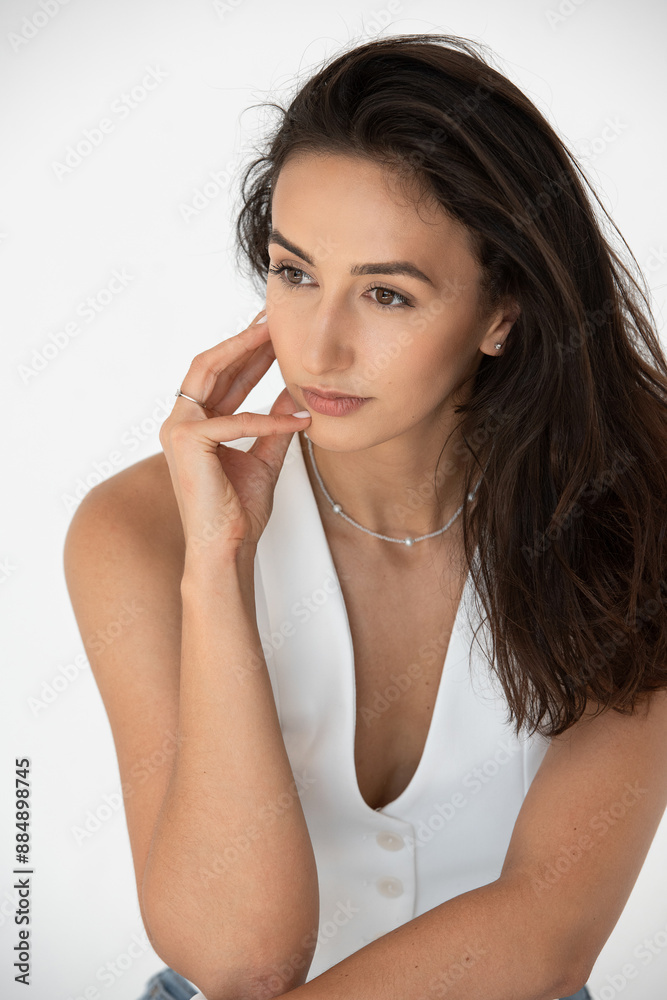 Calm beautiful girl posing in a new hot summer look. Wearing blue jeans and white waistcoat Calm beautiful girl posing in a new hot summer look. Wearing blue jeans and white waistcoat