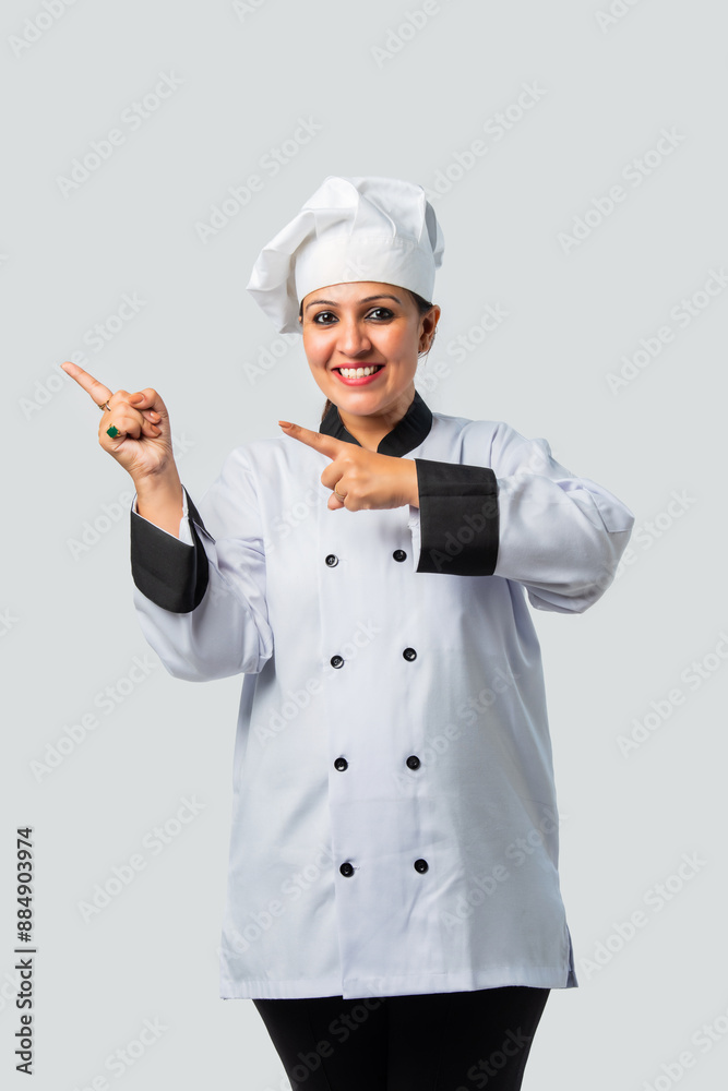 Happy Indian Female Chef or professional cook Pointing at blank - Isolated on White