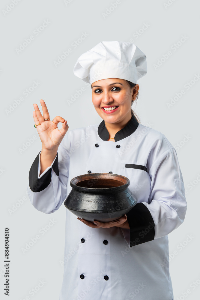 Asian Indian female chef holding biryani in terracotta pot - traditional cuisine professional Asian Indian female chef holding biryani in terracotta pot - traditional cuisine professional