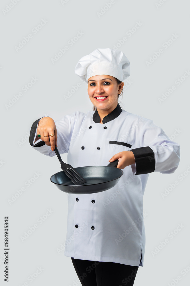 Young female chef with frying pan and spatula isolated on white- professional culinary expert Young female chef with frying pan and spatula isolated on white- professional culinary expert