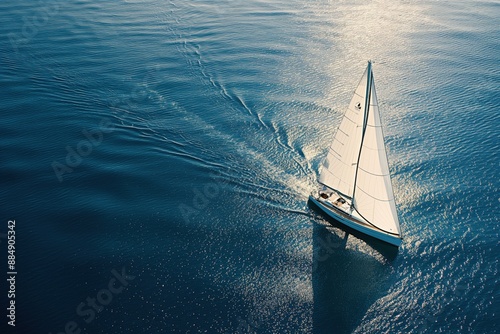 An aerial photo of a sailing yacht in the open sea, with the boat set against the clear blue ocean. Concept for ocean travel and adventure.