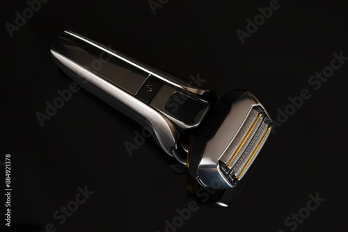 Healthcare and Lifestyle Concepts. Upper View and Closeup Image of 5 Blades Fashionable Electric Shaver On Black Reflective Surface photo