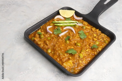 Indian famous dish Mutton matar Kheema Pav or Khima Paav is a minced goat meat curry. Mutton keema is cooked with onion, tomatoes, potatoes, and green peas along with Indian spices. copy sapce. photo