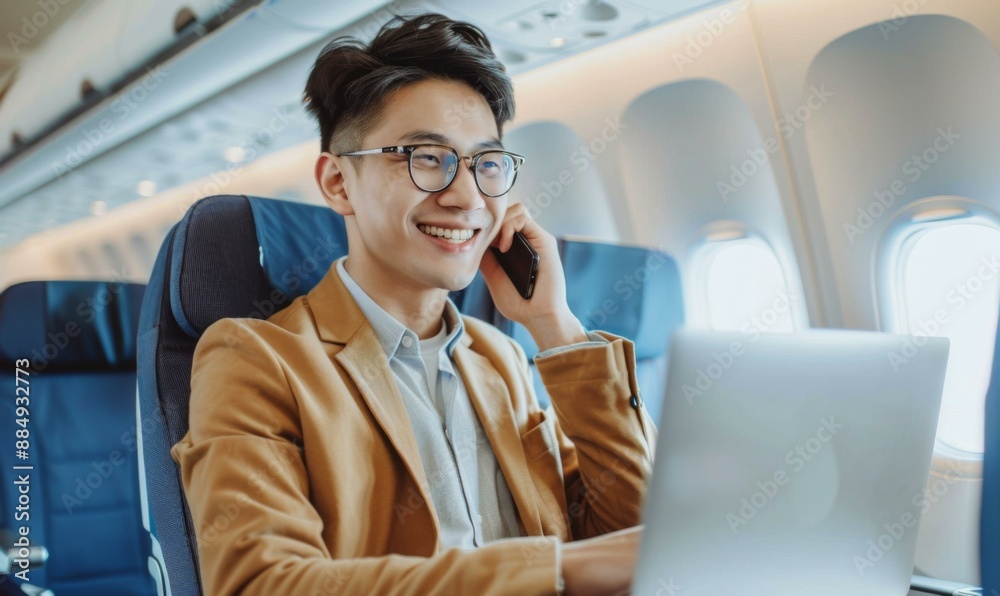 A young businessman is working on his laptop and talking on the phone while flying on a plane. AI. A young businessman is working on his laptop and talking on the phone while flying on a plane. AI.