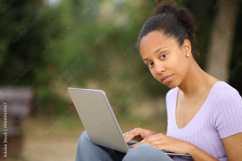 Serious black woman using laptop posing Serious black woman using laptop posing