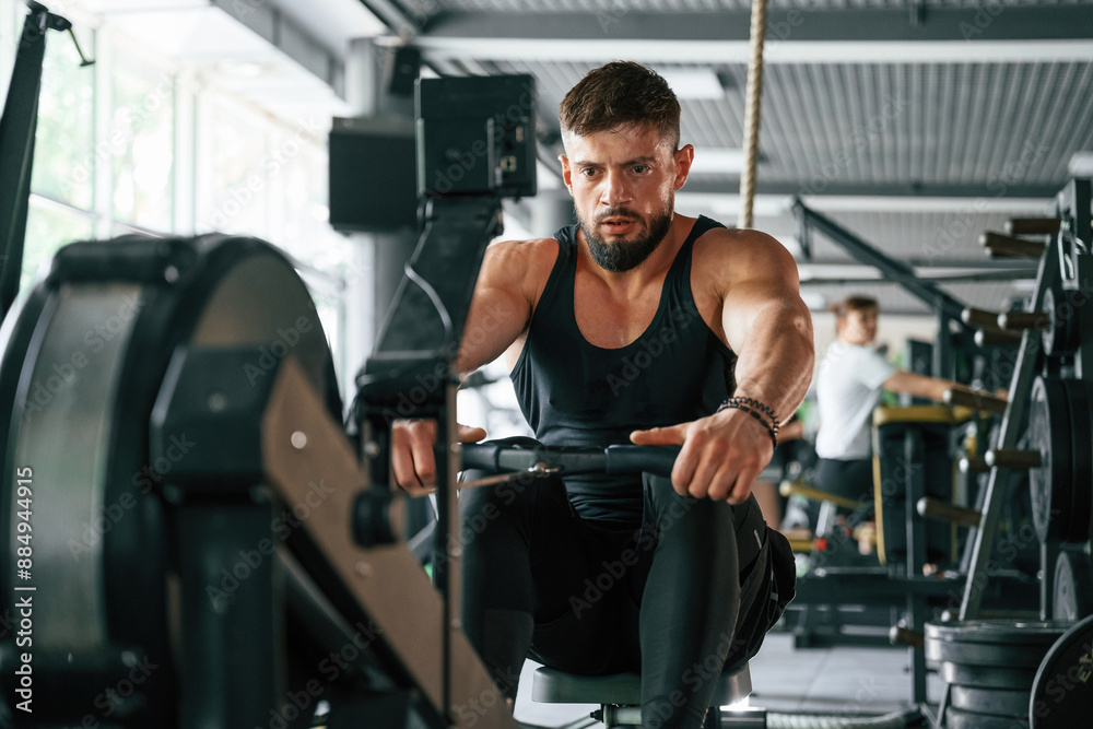 Exercise for stamina. Strong muscular man is working out in the gym