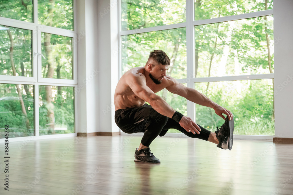 Yoga stretching. Strong muscular man is working out in the gym Yoga stretching. Strong muscular man is working out in the gym