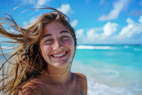 A detailed image of a smiling young woman at the beach, her hair flowing in the breeze, with a vivid blue sea and sky behind her.