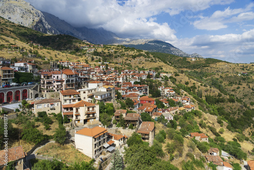 Arachova, Greece - August 11, 2023: High angle and summer view of houses of a village with red foof on the hill against mountain 