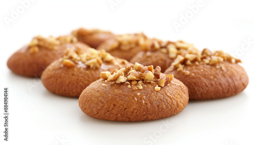 traditional Greek melomakarona, featuring oval-shaped, honey-dipped cookies topped with chopped walnuts, set against a clean white background photo