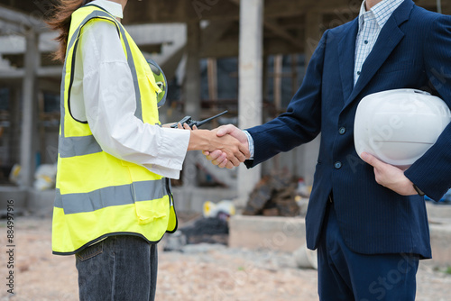 construction worker and contractor. Client shaking hands with team builder in renovation site in the morning.