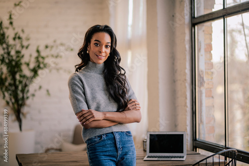 Photos An African American woman standing at a table and looking at camera