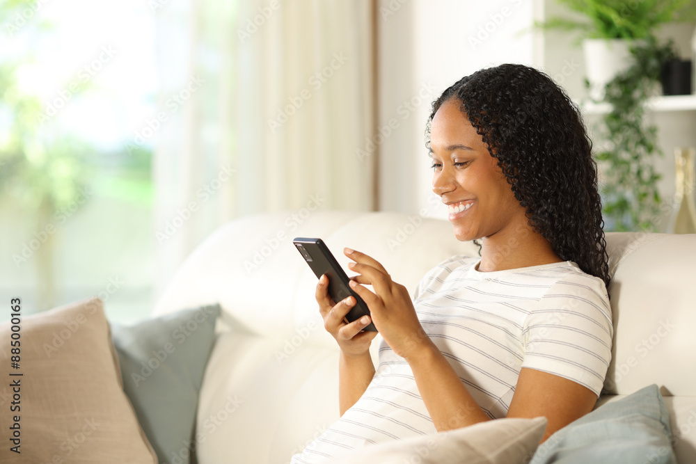 Happy black woman using smart phone at home Happy black woman using smart phone at home
