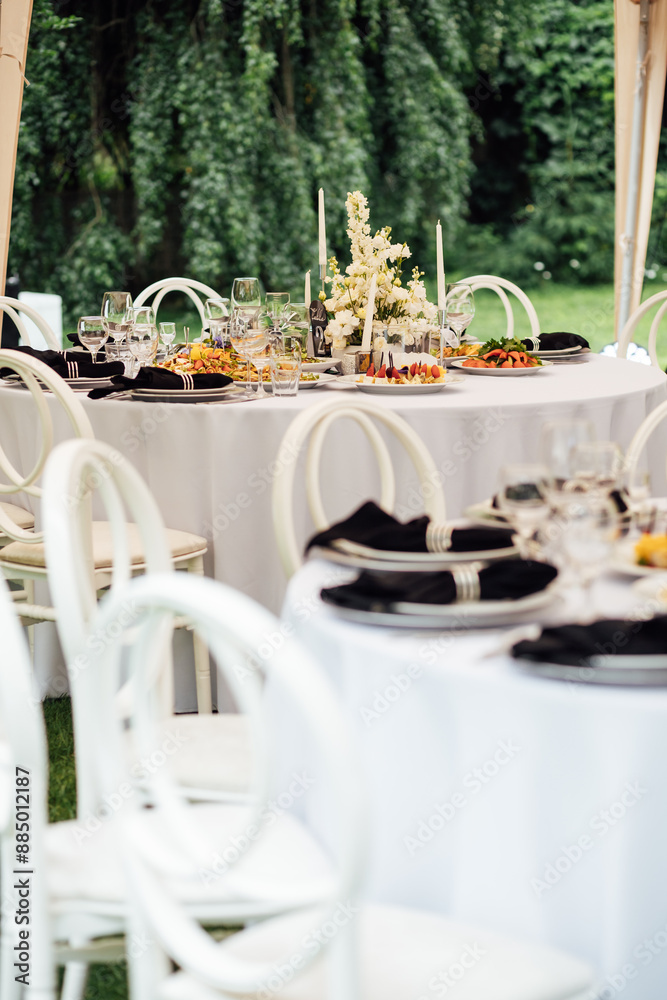 Fototapeta premium Luxurious restaurant. Luxurious interior, white tables, serving dishes and glasses for guests